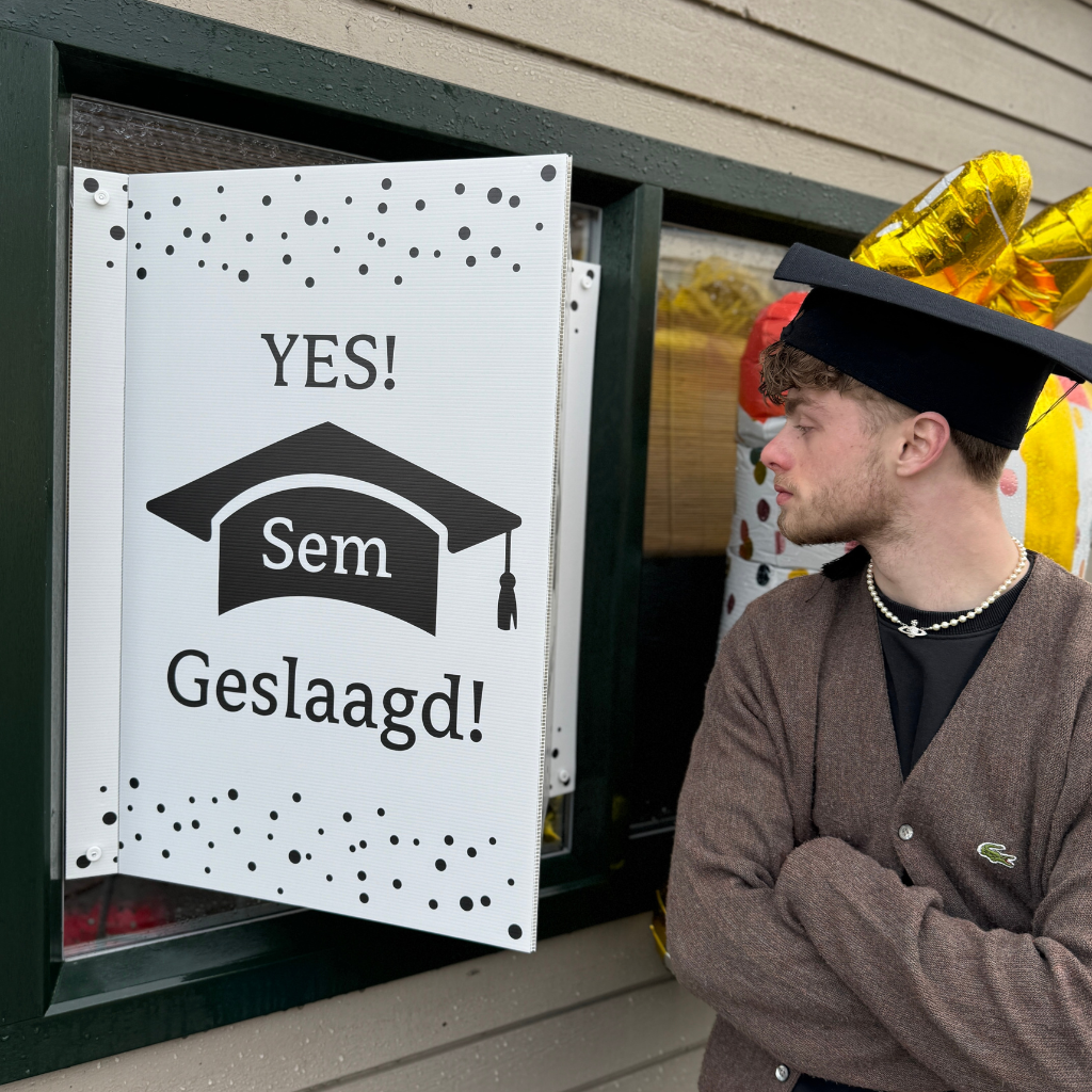 Raambord met afstudeerhoed en gepersonaliseerde naam voor geslaagd moment.